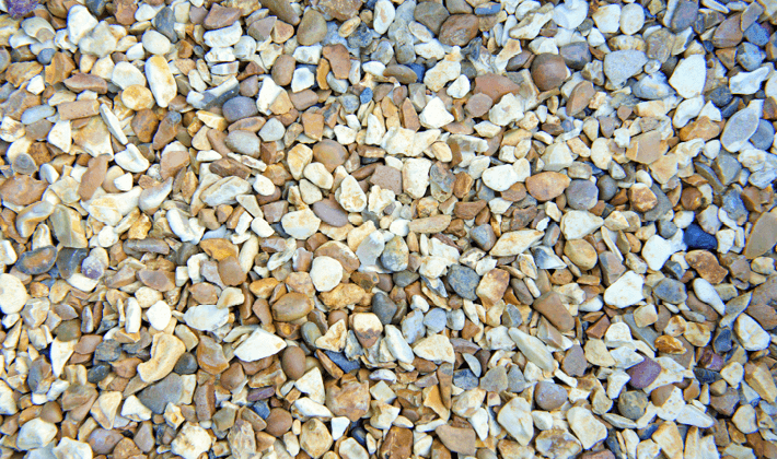 Loose display of shingle with golden, brown and white flint faces, graded from 4mm to 10mm, showcased in a dry condition.