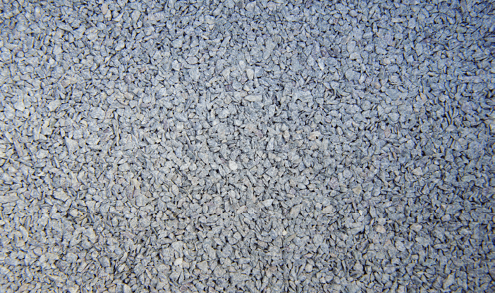 Loose display of joint grit, containing grey, angular granite, graded from 1mm to 4mm, showcased dry.
