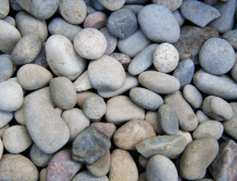 Naturally rounded, multi-coloured, river-washed pebbles, displayed loose.