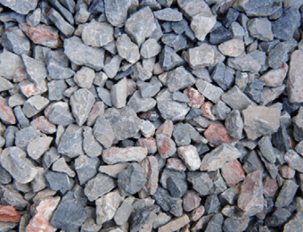 Permeable paving aggregate containing pink and grey angular limestone and granite, displayed loose.